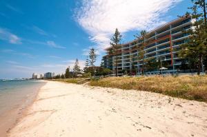 - une plage en face d'un grand bâtiment dans l'établissement Silvershore Apartments on the Broadwater, à Gold Coast