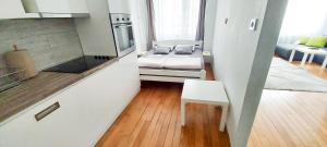ベオグラードにあるHigh White Apartmentsのベッドとキッチンのある小さな部屋