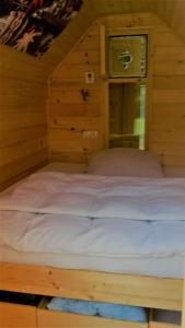 un grande letto in una camera in legno con finestra di Kamp Jankovic a Gorenjcj