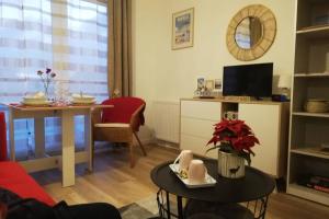 a living room with a table and a dining room at Studio Cosy neuf proximité du Golf et de la Digue in Wimereux