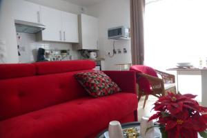 ein Wohnzimmer mit einem roten Sofa und einem Tisch in der Unterkunft Studio Cosy neuf proximité du Golf et de la Digue in Wimereux