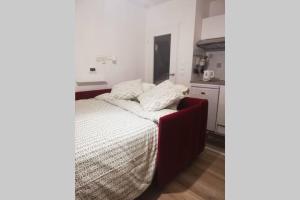 a small bedroom with a bed and a kitchen at Studio Cosy neuf proximité du Golf et de la Digue in Wimereux