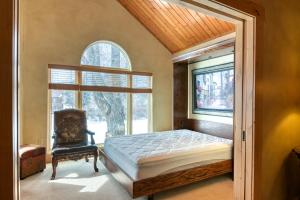 a bedroom with a bed and a window and a chair at Grande Getaway in South Fork