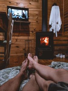 two men laying on a bed in front of a fireplace at Cabana Refúgio - Pousada Colina dos Ventos in Urubici +33 photos