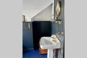 ein Badezimmer mit Waschbecken und Spiegel in der Unterkunft 17th Century Boutique Getaway in the Countryside in Martin