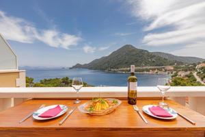 a table with a plate of food and a bottle of wine at Apartments More Luxury in Sobra