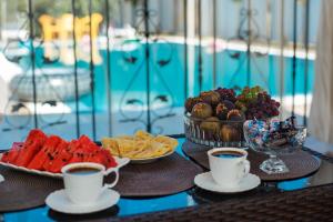 a table topped with cups of coffee and a tray of fruit at #HOME-11 in Batumi