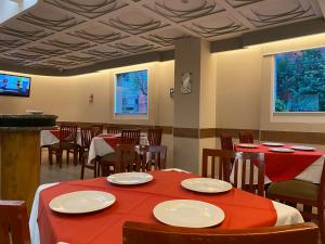 un restaurante con mesas y sillas con mantel rojo en HOTEL MARIA RICO en Ciudad de México