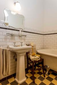 a bathroom with a sink and a bath tub and a mirror at B&B Hostellerie Marie in Eben-Emael