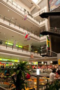 a shopping mall with tables and chairs and people at Hotel San Silvestre in Barrancabermeja