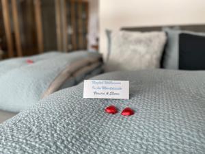 two red hearts on a bed with a note on it at Mountainsuite in Oberwald