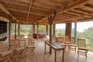 Habitación con sillas de madera, mesa, mesa y sillas. en Casa Bosque de Niebla, en Guasca