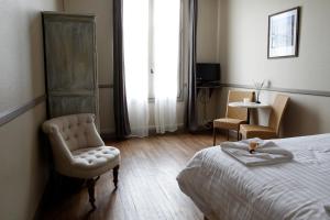 a bedroom with a bed and a chair and a window at Villa Roma B&B in Amboise