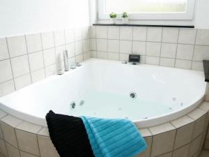 una bañera blanca con una toalla azul. en 6 person holiday home in Hals, en Hals