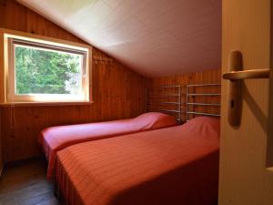 two beds in a small room with a window at Welcoming Cottage in Hatrival with Terrace in Saint-Hubert