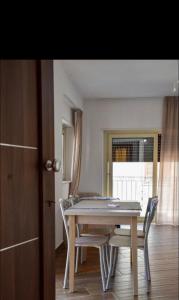 jadalnia ze stołem i krzesłami oraz oknem w obiekcie B&B Samuel Fish w mieście Bagnara Calabra