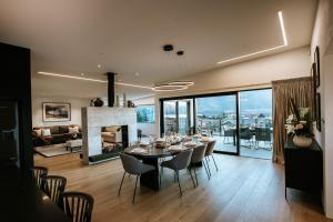 comedor y sala de estar con mesa y chimenea en The Heights - Sleeps 8 - Lake Views - Outdoor Fire, en Wanaka