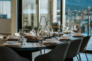 Una mesa con vasos y platos de comida encima. en The Heights - Sleeps 8 - Lake Views - Outdoor Fire, en Wanaka 13 fotos más