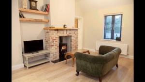 a living room with a couch and a fireplace at Lavender Cottage - 2 Bedroom Home in Newbridge