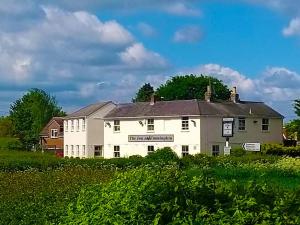 un edificio blanco con una señal frente a un campo en The Inn at Emmington en Chinnor