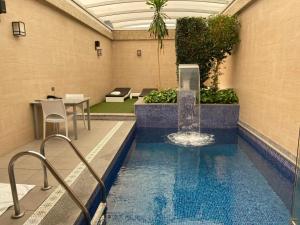 una piscina con una fuente en un edificio en Zouk Hotel, en Alcalá de Henares