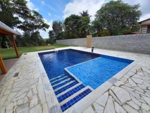 uma piscina com água azul num quintal em Chácara com Piscina-JundiaÍ SP em Jundiaí