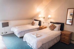 a hotel room with two beds and a tv at Elder York Guest House in Edinburgh