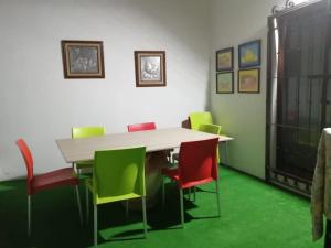 a dining room with a table and colorful chairs at Casa Guelaguetza By Rotamundos in Oaxaca City