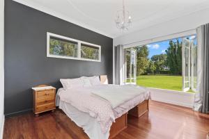 een slaapkamer met een bed en een raam bij Somerton - Waipu Holiday Home in Waipu Cove