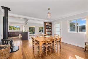 een keuken en eetkamer met een tafel en stoelen bij Somerton - Waipu Holiday Home in Waipu Cove