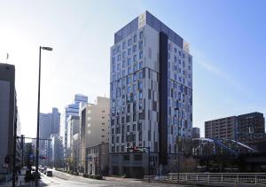 um edifício alto no meio de uma cidade em Far East Village Hotel Yokohama em Yokohama