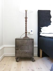 uma velha mala de metal sentada no chão ao lado de uma cama em ApartmentInCopenhagen Apartment 1141 em Copenhague