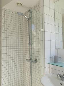 una ducha con una puerta de cristal junto a un lavabo en ApartmentInCopenhagen Apartment 1141, en Copenhague