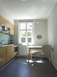 コペンハーゲンにあるApartmentInCopenhagen Apartment 1142のキッチン(テーブル、椅子付)、窓