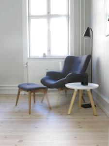 コペンハーゲンにあるApartmentInCopenhagen Apartment 1142の青い椅子とサイドテーブルが備わります。