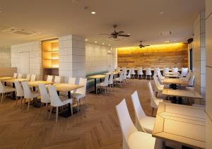 a restaurant with wooden tables and white chairs at Far East Village Hotel Yokohama in Yokohama