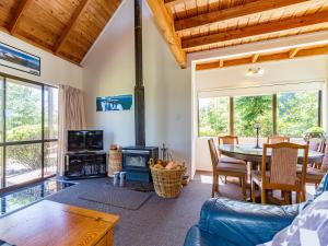 ein Wohnzimmer mit einem Tisch und einem Kamin in der Unterkunft Mike 'n' Marion's - National Park Holiday Home in National Park