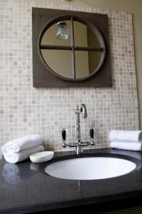 La salle de bains est pourvue d'un lavabo, d'un miroir et de serviettes. dans l'établissement Villa Roma B&B, à Amboise