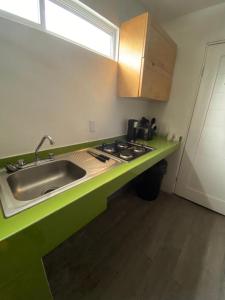 a kitchen with a sink and a green counter top at Casa moderna equipada como en pequeño hotel hab 4 in Monterrey +2 photos