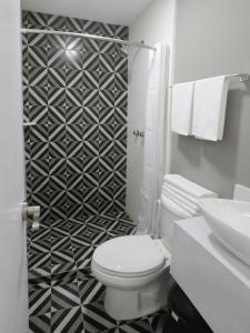a bathroom with a toilet and a black and white patterned wall at Casa moderna equipada como en pequeño hotel hab 4 in Monterrey