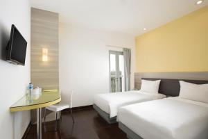 a hotel room with two beds and a desk at Amaris Hotel Bengkulu in Bengkulu +17 photos