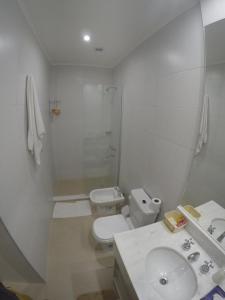 a white bathroom with a toilet and a sink at Bonaire V apartamento 2 Personas a 1 cuadra de la costanera in Corrientes