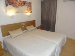 a bedroom with a white bed and a window at Sunorama Beach Apartment in Larnaca