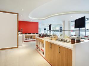 une grande cuisine avec un comptoir et une aire de restauration dans l'établissement Asyana Kemayoran Jakarta, à Jakarta