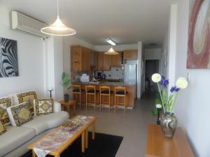 a living room with a couch and a table at Sunorama Beach Apartment in Larnaca