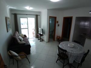 a living room with a table and a couch at Praia grande, aviação, apenas 180 mtrs do mar!!! in Praia Grande