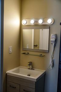 a bathroom with a sink and a mirror and a hair dryer at Skyland Motel Inn & Suites in Huntsville