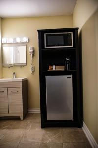 a small kitchen with a microwave and a sink at Skyland Motel Inn & Suites in Huntsville
