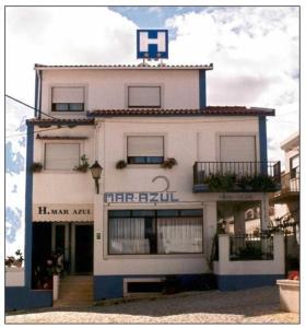 um grande edifício branco com um cartaz em Marazul em Serra d'el-Rei