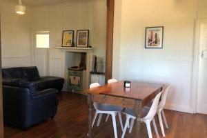 ein Wohnzimmer mit einem Holztisch und einer Couch in der Unterkunft Twilight Cottage in Esperance + 13 Fotos
